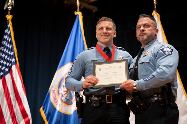 Sergeant Jeremy Depies poses with Minneapolis Police Chief Brian O Hara after he was awarded a medal of valor for rescuing a drowning four-year-old during the annual awards ceremony for the Minneapolis Police Department at the Ukrainian Cultural Center in Minneapolis on Tuesday.
