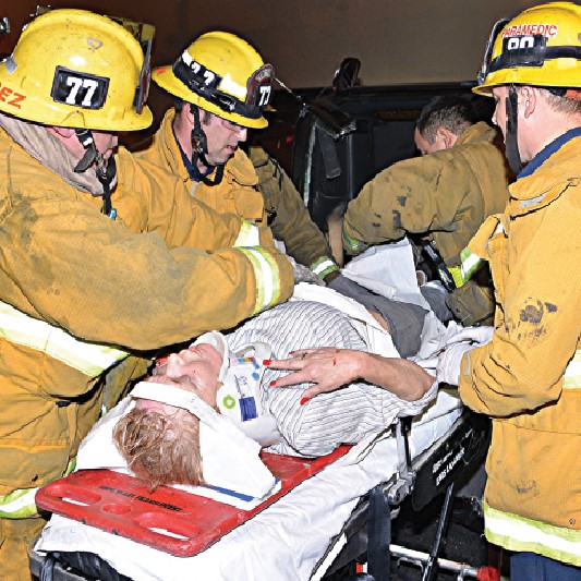 Los Angeles firefighter/paramedics tighten a sheet around the fractured pelvis of an accident victim. (Photo: Rick McClure) 