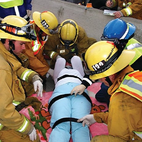 A blanket is placed under a trauma victim to wrap her in and keep her warm. (Photo: Rick McClure) 