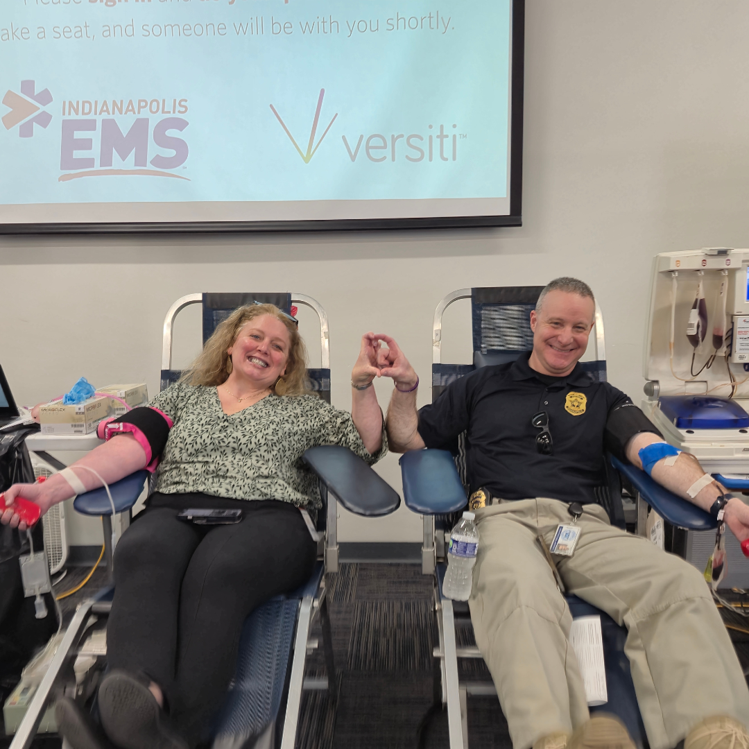 Indiana police officer and EMS provider donating blood together.
