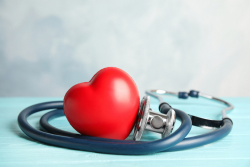 A red plastic heart with a stethoscope wrapped around it