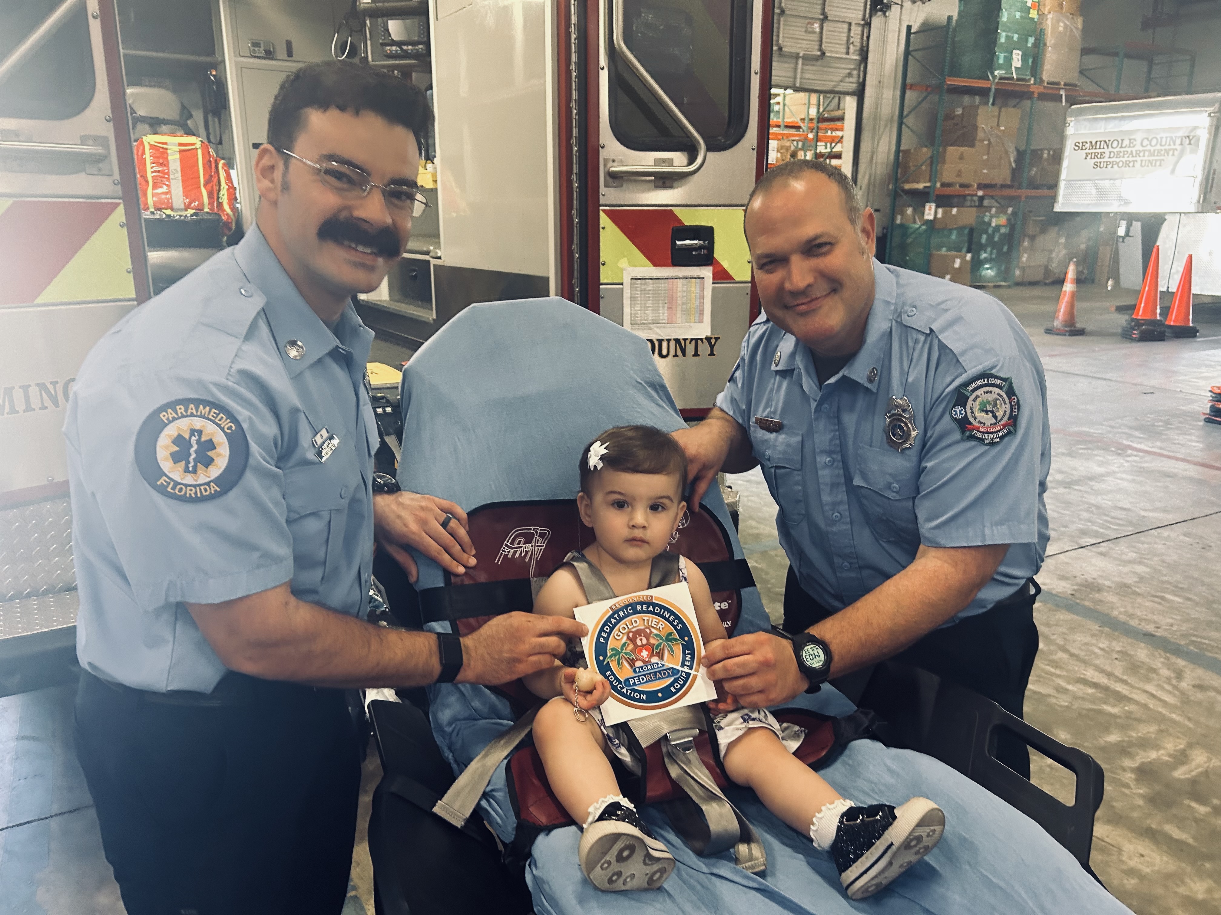 SCFD paramedics with pediatric patient displaying gold tier status award