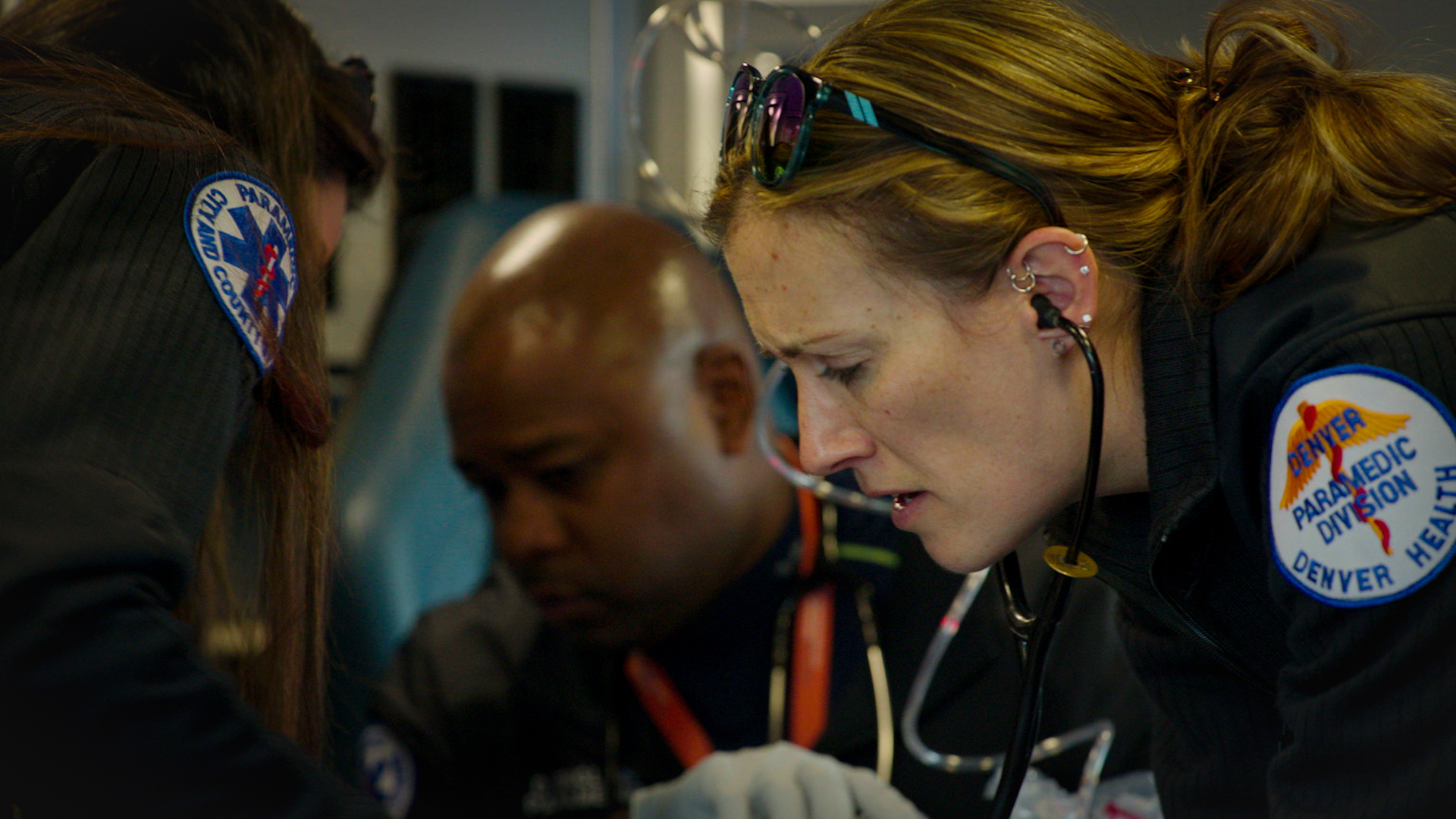 Still from Into the Unknown showing a paramedic team working on a patient in the back of an ambulance