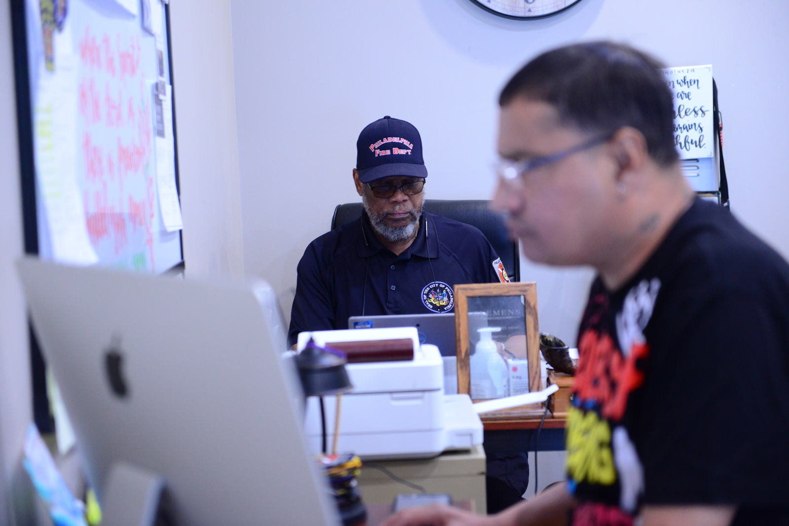 Rick Robinson (rear) looks over the caseload in an office shared with Rock Ministries’ Ramon Crespo. Robinson is a case manager with AR-2 and is a certified addiction counselor and behavioral health technician. Case managers ride with medics in marked SUVs as well as check in periodically on people enrolled in the system.