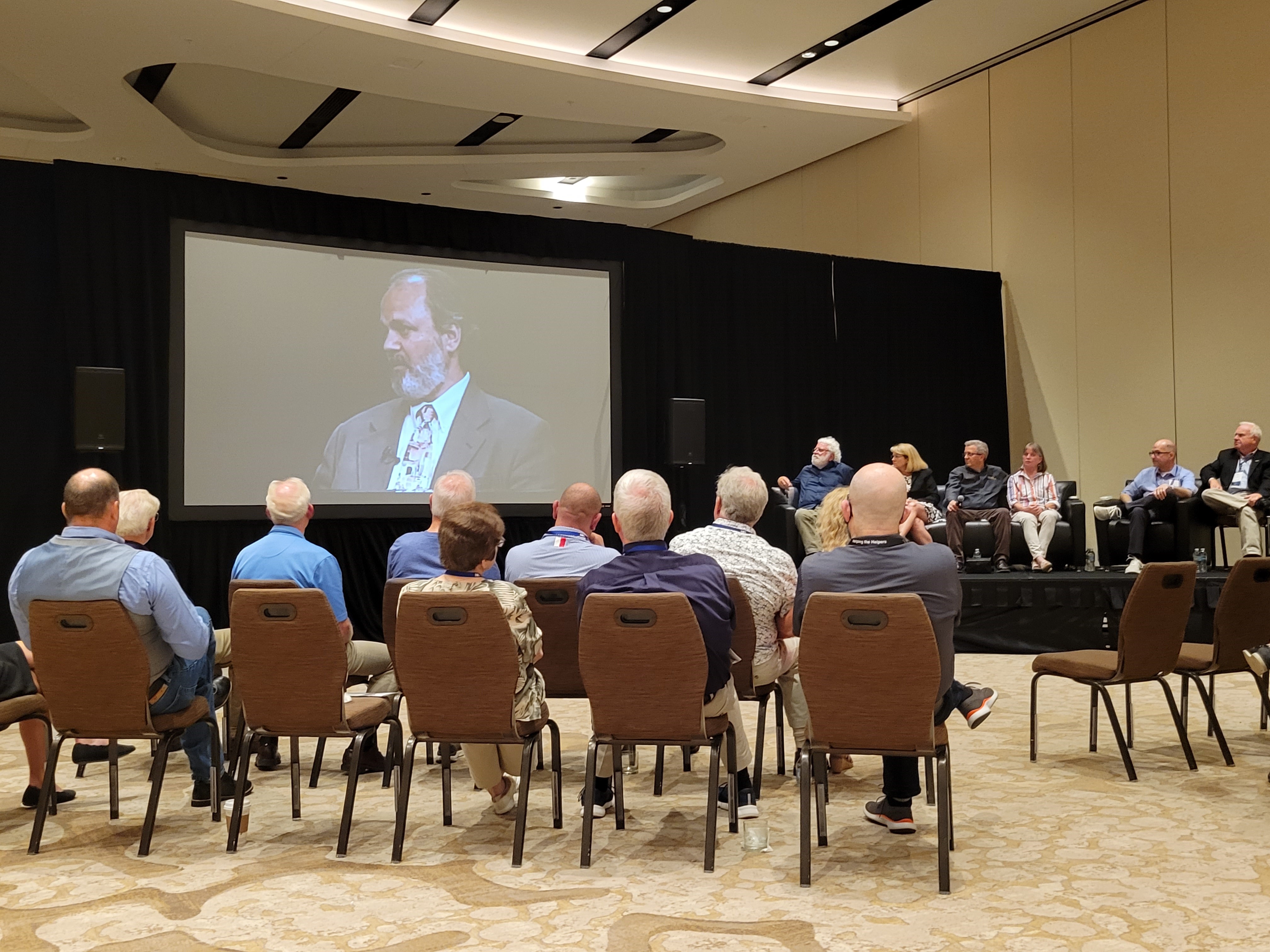 Pinnacle attendees watch a tribute video at Stout's celebration of life. 