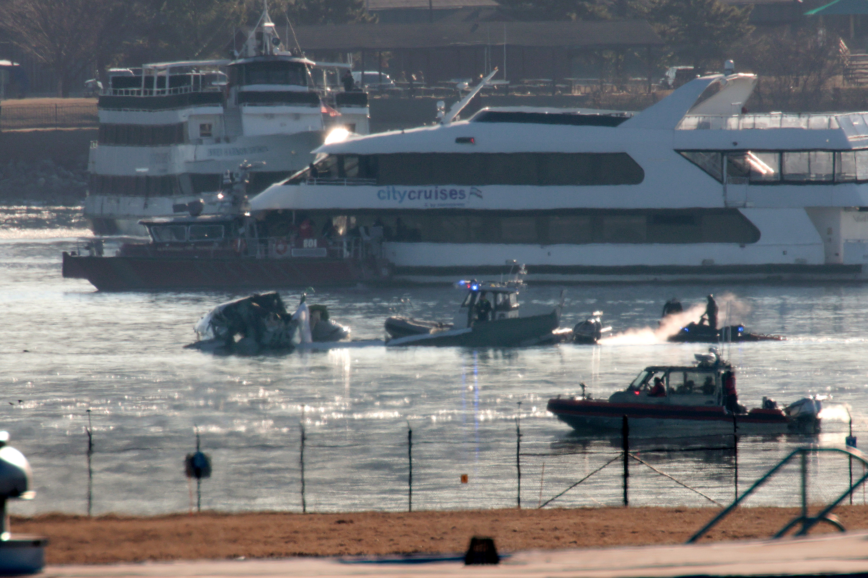 Emergency response units search the wreckage of an American Airlines plane on the Potomac River after it crashed on approach to Reagan National Airport on Jan. 30, 2025, in Arlington, Virginia. The American Airlines flight from Wichita, Kansas collided midair with a military Black Hawk helicopter while on approach to Ronald Reagan Washington National Airport. According to reports, there were no survivors among the 67 people on both aircraft. 