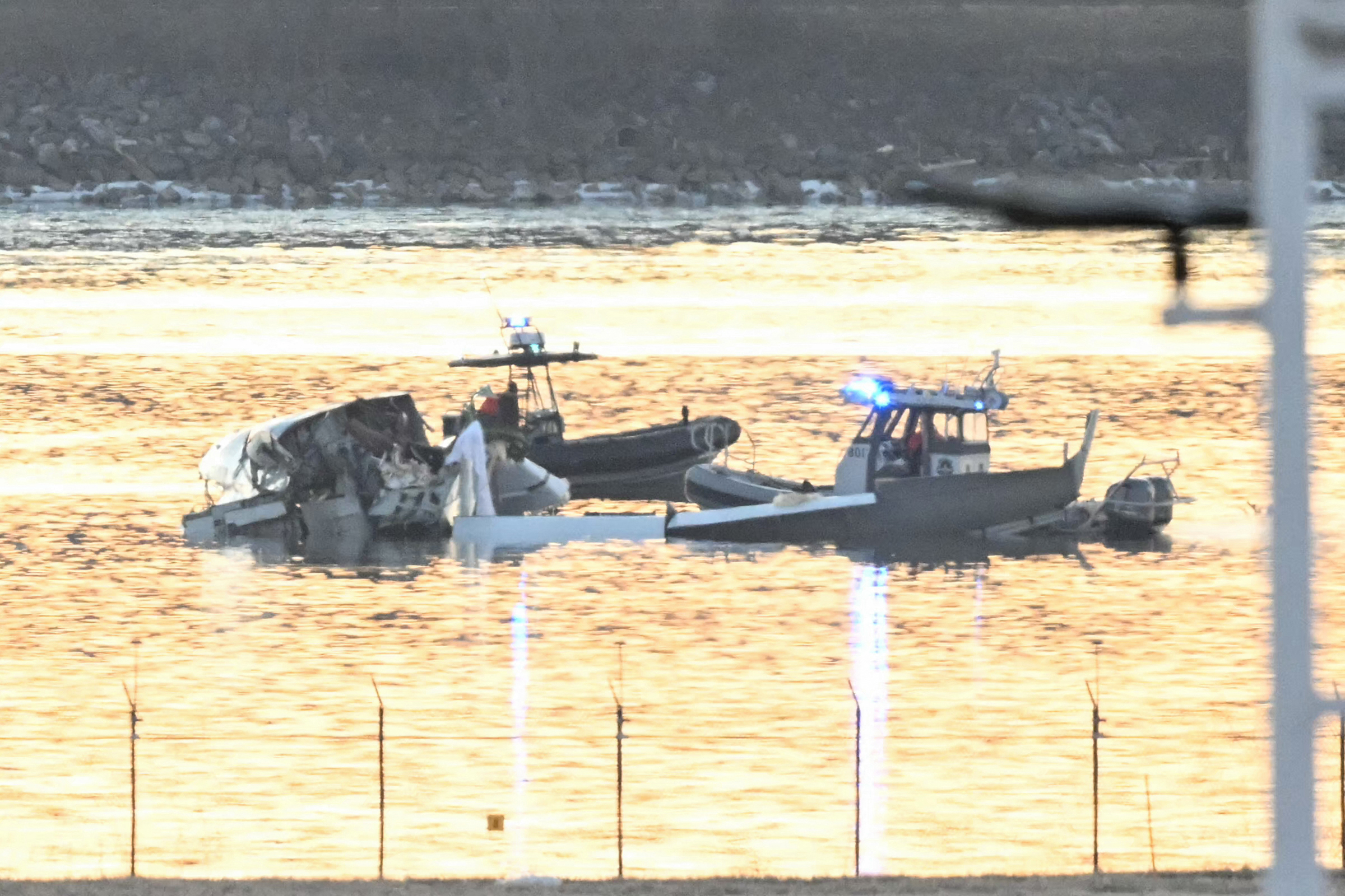 Part of the wreckage is seen as rescue boats search the waters of the Potomac River after a plane on approach to Reagan National Airport crashed into the river outside Washington, D.C., Jan. 30, 2025. A regional jet from Kansas crashed into Washington's Potomac River after colliding mid-air with a military helicopter near Reagan National Airport, officials said January 29, prompting a major emergency response and grounding all flights. 