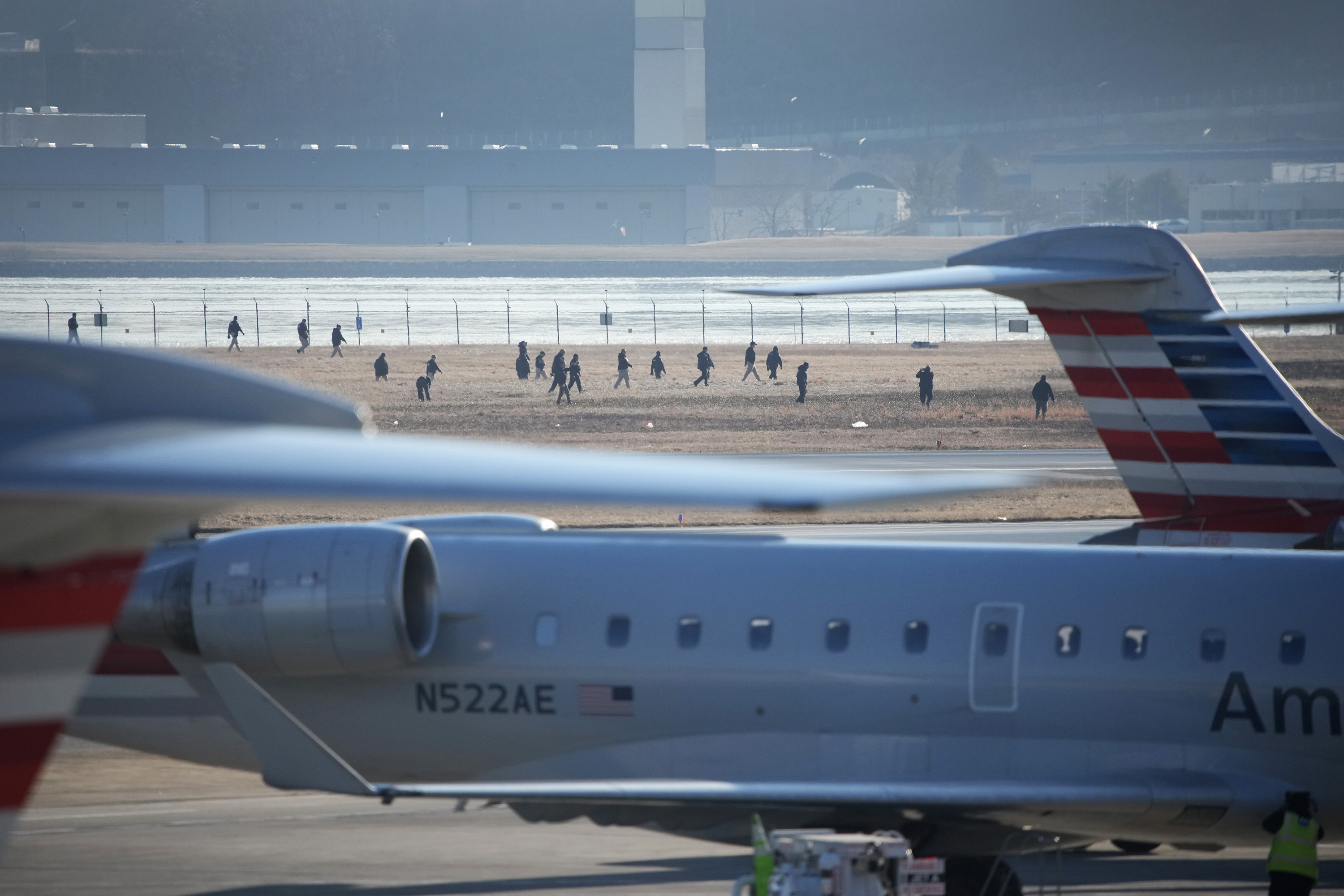 Investigators walk the grounds of the Reagan National Airport as they work after the crash last night of the American Airlines plane on the Potomac River as it approached the Reagan National Airport on Jan. 30, 2025, in Arlington, Virginia. The American Airlines flight from Wichita, Kansas collided in midair with a military helicopter while approaching Ronald Reagan National Airport. According to reports there were no survivors amongst the 67 people on board both aircraft.
