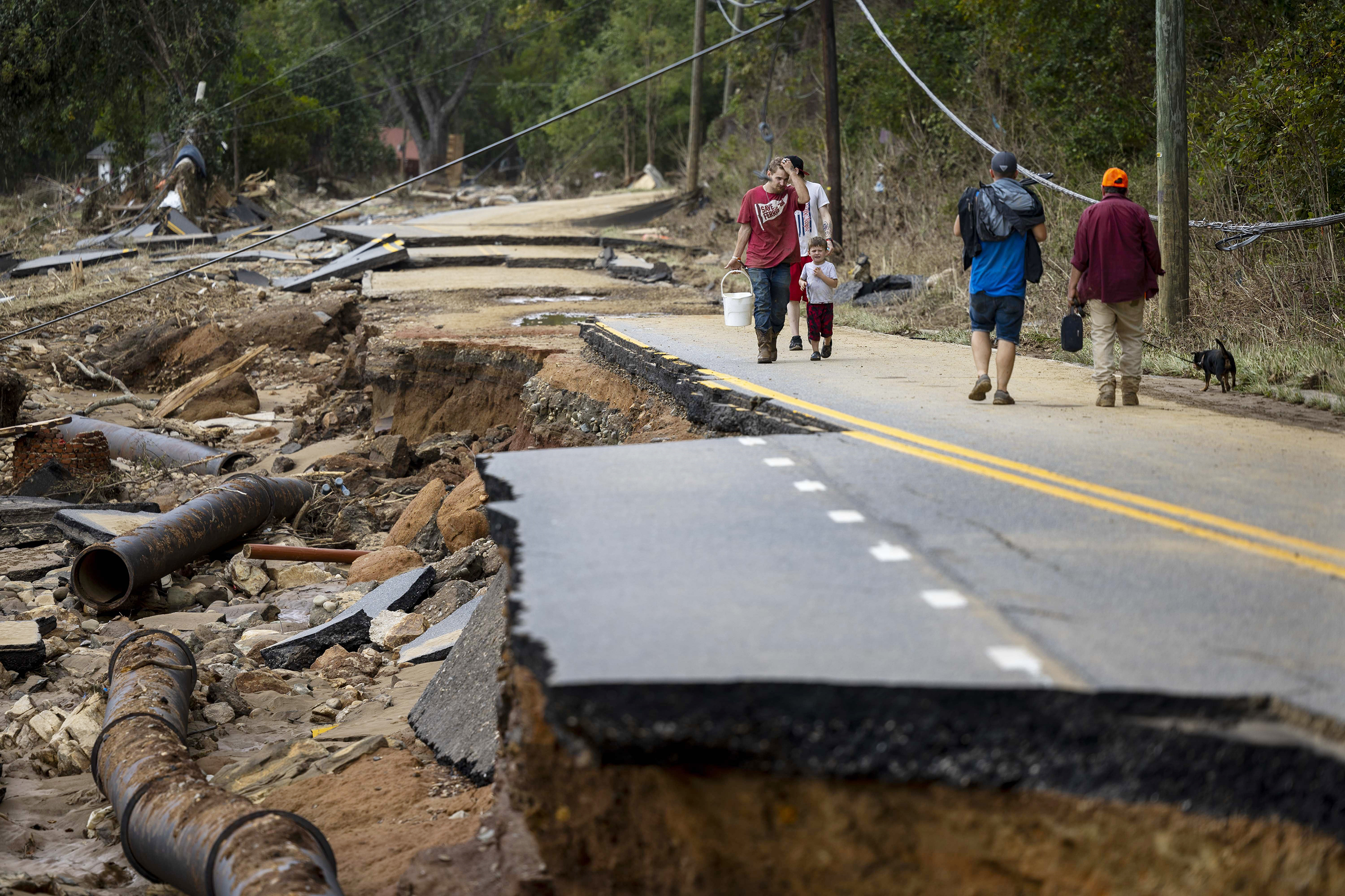 Swannanoa residents walk through devastating flood damage from the Swannanoa River on Sept. 29, 2024. The remnants of Hurricane Helene caused widespread flooding, downed trees, and power outages in western North Carolina. (Travis Long/The News & Observer/TNS) 