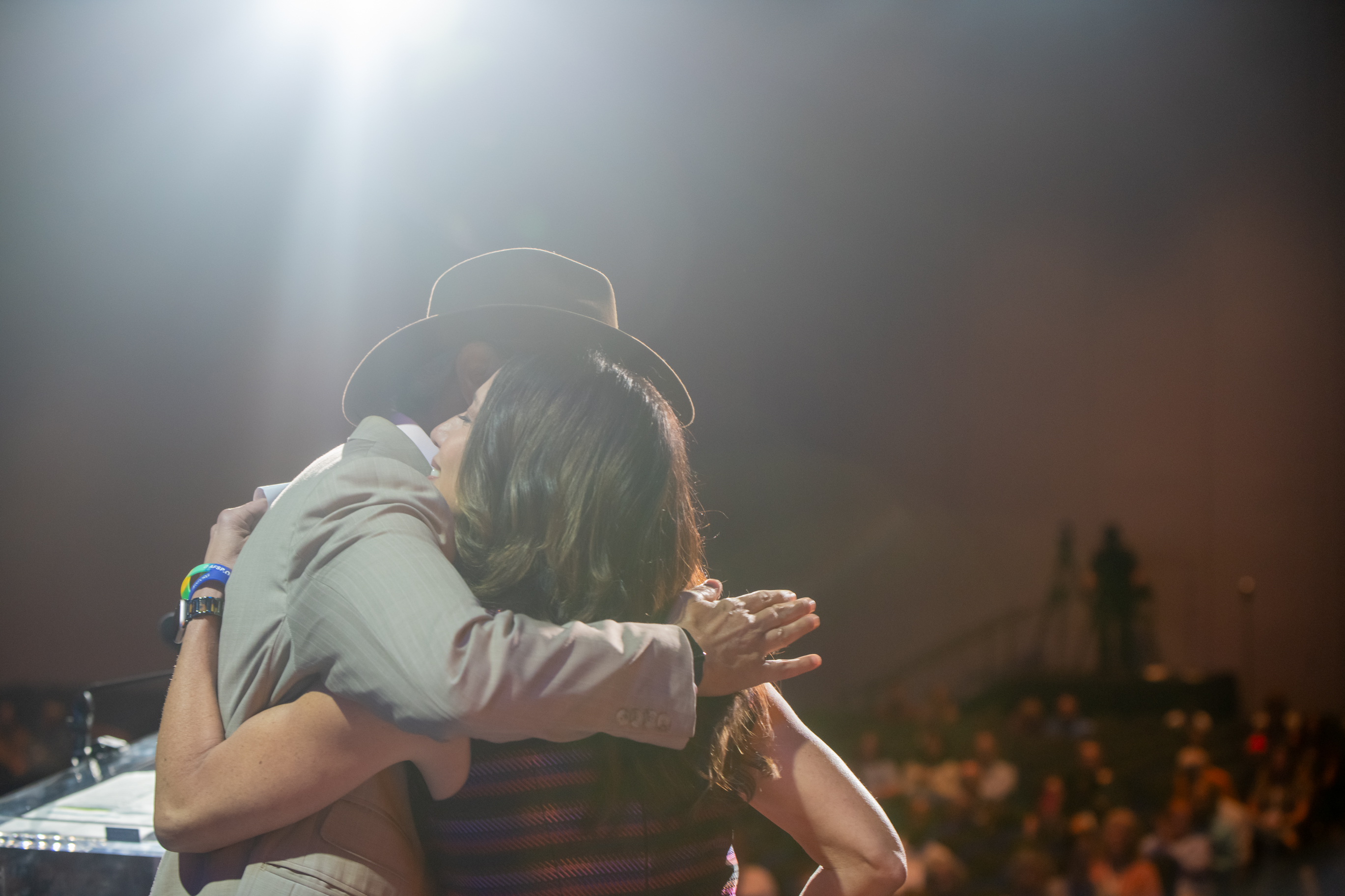 Rakesh Jain, MD, and Christine Moutier, MD, CMO, embrace following the introduction of the Eric C. Arauz Memorial Keynote Address.