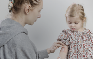woman applies ointment to child