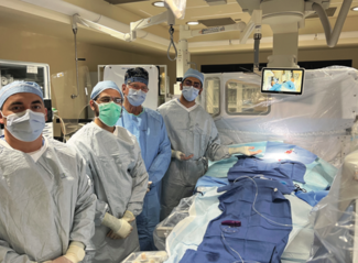 Figure 1. “New Dog” (see Table): Cath lab team without lead aprons behind the Protego system (Image Diagnostics).