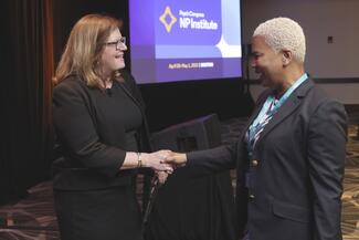 Julie Carbray greets an attendee at the 2023 NP Institute in Boston