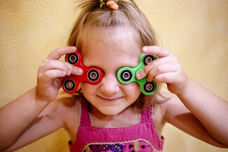A young child wears goofy sunglasses and smiles