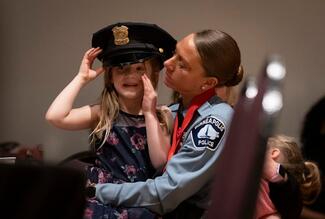 Officer Ashley Bergersen s daughter Lillian, 5, tries on her hat after she was awarded a Medal of Valor for rescuing a drowning four-year-old during the annual awards ceremony for the Minneapolis Police Department at the Ukrainian Cultural Center in Minneapolis, Minn., on Tuesday April 30, 2024.
