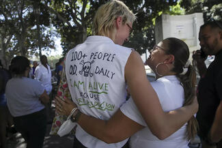 Finn Settles, 24, left, and Renee Arellano, 45, greet each other at a 2022 rally in Los Angeles marking International Overdose Awareness Day. (Irfan Khan/Los Angeles Times/TNS)