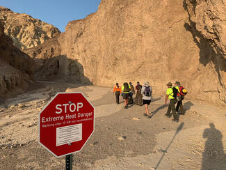 A rescue team sets out on the Golden Canyon Trail in Death Valley. Temperatures there may not drop below 100 degrees over the next three days, with daytime highs reaching up to 125 degrees, the National Weather Service said. ( Death Valley National Park/TNS)