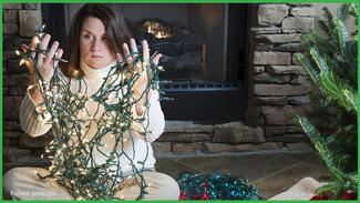 Frustrated woman holding tangled holiday lights