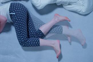 a person with restless leg syndrome lies in bed
