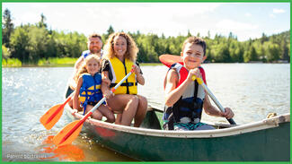 Smiling family rowing a boat