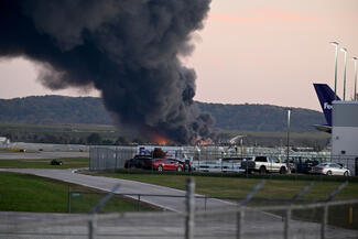 Fire and smoke mark where a UPS cargo plane crashed near Louisville Muhammad Ali International Airport on Tuesday, Nov. 4, 2025, in Louisville, Kentucky. The fully fueled plane crashed shortly after takeoff, with a shelter-in-place order issued for within 5 miles of the airport. (Stephen Cohen/Getty Images/TNS)