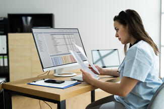 A clinician reviews data on a computer