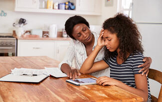 a mother and daughter sit at a table