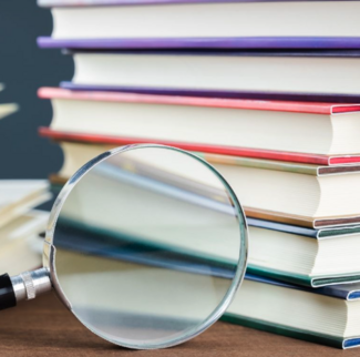 Books and a magnifying glass on a desk