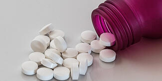 pills spilling out of a tipped over pill bottle
