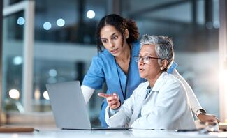 A nurse and a doctor review information on a computer in a lab clinical study research trial