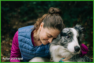 A woman smiling and hugging a dog