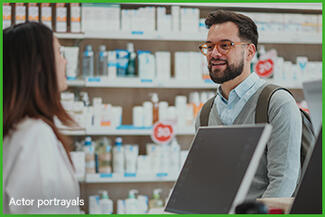 A woman talking to a pharmacist at the pharmacy counter