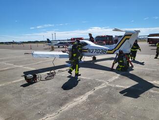 During the initial full-scale exercise session, Venice Fire & Rescue personnel stabilize a disabled Beechcraft Skipper, donated by the Florida Flight Training Center, while establishing scene control and mitigating hazards within the Incident Command System (ICS) framework.