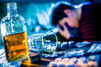 a man surrounded by alcohol and other substances on a table