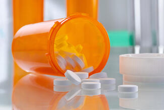 pills spilling out of a tipped over pill bottle