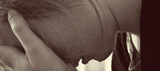 a woman holds her head in her hands