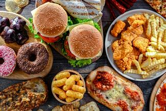 A selection of ultraprocessed foods, including donuts, hamburgers, pizza, and fries.