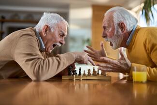 two senior white men fight over a chess game