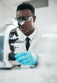 Researcher-looking-through-microscope