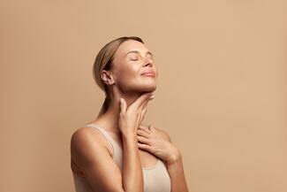Smiling woman touching neck