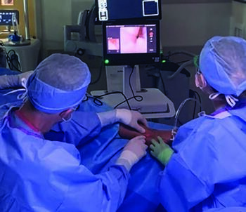 In this photo, one can see the attachment of the arthroscope to a tablet imaging device during a procedure.